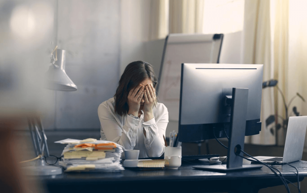 Christian office worker praying silently at a desk before beginning the workday.